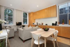 a kitchen and living room with a table and chairs at StayCentral - Merigold on Collins in Melbourne