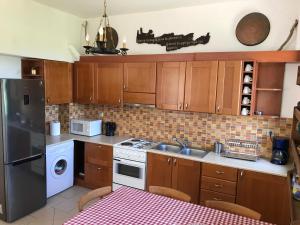 a kitchen with wooden cabinets and a stove top oven at Temenia House in Teménia