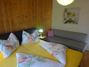 a bedroom with a yellow bed with pillows and a bench at FeWo Graz in Graz