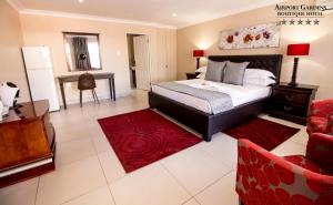 a bedroom with a bed and a red rug at Airport Gardens Boutique Hotel in Boksburg