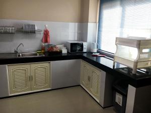 a kitchen with a sink and a microwave at TAcozy693 in Hat Yai