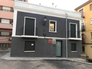 a black building with windows and a street at Cuencaloft La Plazeta in Cuenca