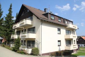 ブラウンラーゲにあるWohlfühlort in der Ferienresidenz Wurmbergblickの茶色の屋根の白いアパートメントビル