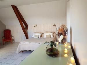 
a room with a bed, a table and a lamp at Le Champ du Pré in Gièvres
