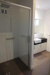 a bathroom with a glass shower and a sink at BIG4 Ceduna Tourist Park in Ceduna