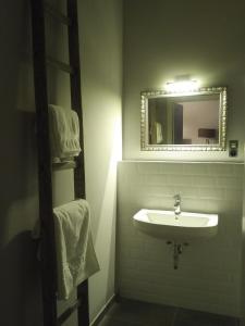 a bathroom with a sink and a mirror and towels at Ferienhaus Pfaffensee in Harthausen