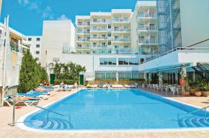 a swimming pool with lounge chairs and a large building at BLUESEA Piscis - Adults Only in Port d'Alcudia