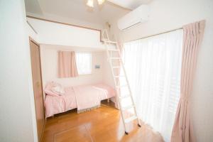 een slaapkamer met een stapelbed en een ladder bij Zushi Beach House in Zushi