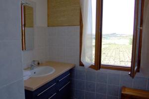a bathroom with a sink and a window at Le Clos Boisé in Théziers