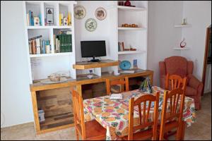 comedor con mesa y TV en Casa Sol, en Conil de la Frontera