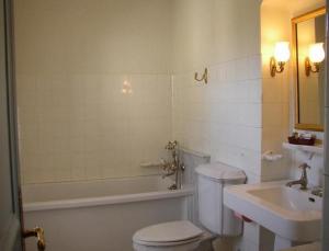 a white bathroom with a toilet and a sink at Appartement du Château du Grand Bouchet in Ballan-Miré +6 photos