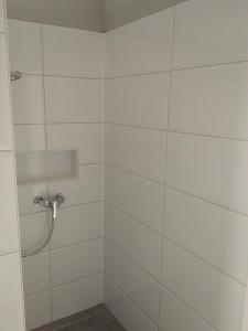 a bathroom with a shower with white tiles at Ferienhaus Pfaffensee in Harthausen