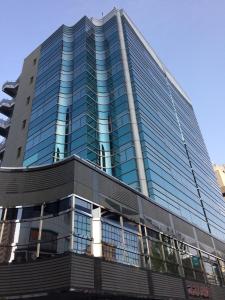 un edificio alto con ventanas de cristal azul en Dormy Inn Korakuen en Tokio