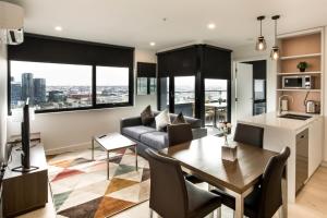 a living room filled with furniture and a large window at Spencer Street Apartments in Melbourne