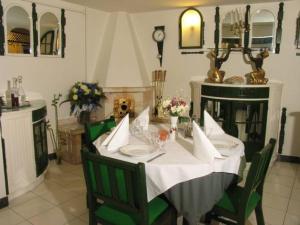 a dining room with a white table and green chairs at Pensiunea Ana Maria in Târgu-Mureş