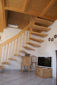 a living room with wooden stairs and a tv at Chalet Lenzerheide-Sporz in Lenzerheide
