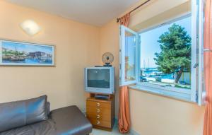 ein Wohnzimmer mit einem TV und einem Fenster in der Unterkunft Apartment Riva Porec in Poreč