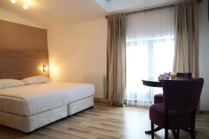 a hotel room with a bed and a desk and a window at Studio ApartCity in Braşov