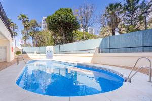 a swimming pool with blue water in a building at Beachfront Apartment Marbella in Marbella