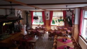 a dining room with tables and chairs in a restaurant at Obere Schweizerhütte in Oberhof