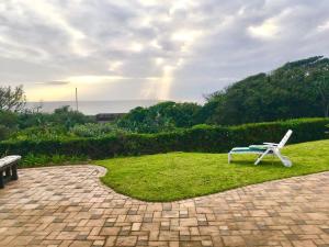 a bench and a chair sitting on the grass at Sea Forever in Pennington