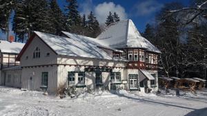 ein großes weißes Haus mit Schnee auf dem Boden in der Unterkunft Obere Schweizerhütte in Oberhof