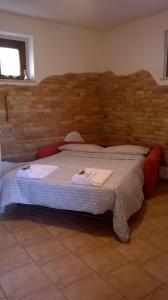 ロレート・アプルティーノにあるLa stalla di nonno Zopitoのレンガの壁の客室で、大型ベッド1台を利用できます。
