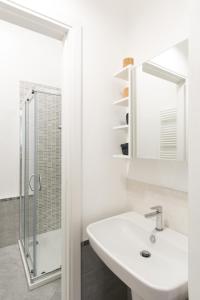 a white bathroom with a sink and a shower at Belvedere White Flat in Trieste