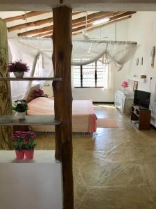 ein Schlafzimmer mit einem Bett und Blumen in einem Zimmer in der Unterkunft Tradewinds Lodge in Diani Beach