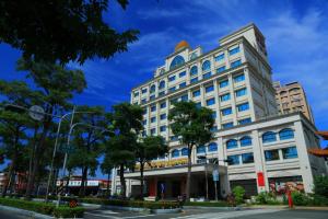 ein großes weißes Gebäude in einer Stadtstraße in der Unterkunft Royal Gold Hotel in Kaohsiung