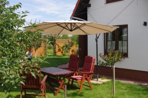 a table and chairs under an umbrella in a yard at Ahorn II in Rydzewo