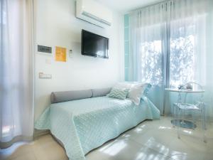 a bedroom with a bed and a tv on the wall at Verdeacqua in Monterosso al Mare