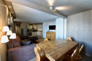 a living room with a wooden table and a couch at A21 Roc de Péclet in Val Thorens