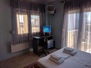 a bedroom with a bed and a desk with a computer at Prinos Apartment in Prinos