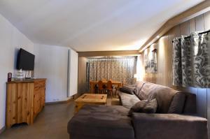 ein Wohnzimmer mit einem Sofa und einem Tisch in der Unterkunft A21 Roc de Péclet in Val Thorens