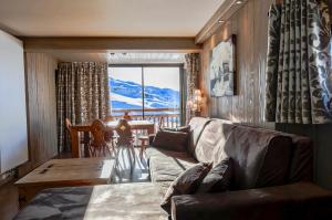 un soggiorno con divano e tavolo di A21 Roc de Péclet a Val Thorens