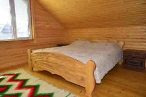 - une chambre avec un lit dans une cabane en rondins dans l'établissement Хатина в Карпатах, à Verkhovyna