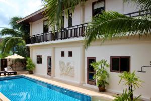 a villa with a swimming pool in front of a house at Sibaja Palms Sunset Beach Luxury Villa in Taling Ngam Beach