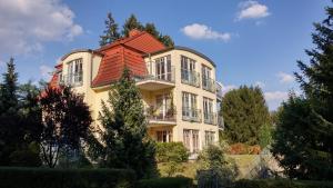 a large yellow house with a red roof at Seeblick III in Bad Saarow