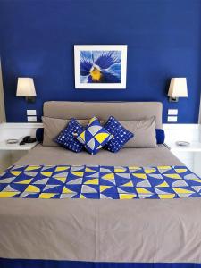 a blue bedroom with a bed with pillows on it at Hotel Della Piccola Marina in Capri