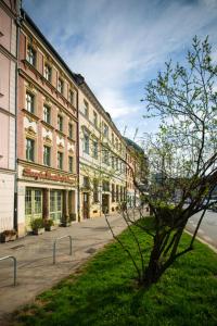 a row of buildings on a street with a tree at Boogie Deluxe Old Town in Wrocław +72 photos