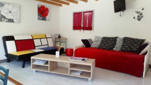 a living room with a red couch and a table at gite du devez des bruyéres in Prades