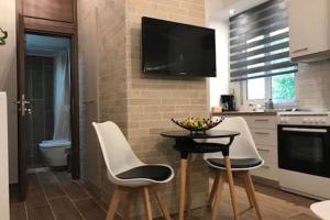 kuchnia z 2 białymi krzesłami i stołem z telewizorem w obiekcie Cozy studio 50m from sea w Atenach +25 zdjęć