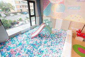 uma sala de baile com uma piscina de bolas com escorrega em Hotel Liyaou em Chiayi