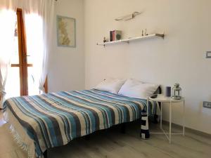 a bedroom with a bed and a table and a window at Un angolo di paradiso a due passi dal mare in Capo Coda Cavallo