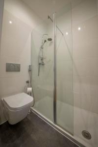 a white bathroom with a shower and a toilet at A Captivating Apartment close to River Tagus in Lisbon in Lisbon