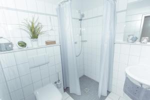
a bathroom with a shower, toilet and sink at Garni Hotel & Appartements Nordstrand in Nordstrand
