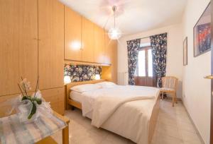 a bedroom with a large white bed and a table at Inn Aosta Apartments in Aosta