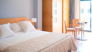 a bedroom with a bed and a table and a chair at Hotel Clipper - EL DELFÍN VERDE RESORTS - Platja de Pals in Torroella de Montgrí