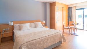 a bedroom with a bed and a table and a chair at Hotel Clipper - EL DELFÍN VERDE RESORTS - Platja de Pals in Torroella de Montgrí